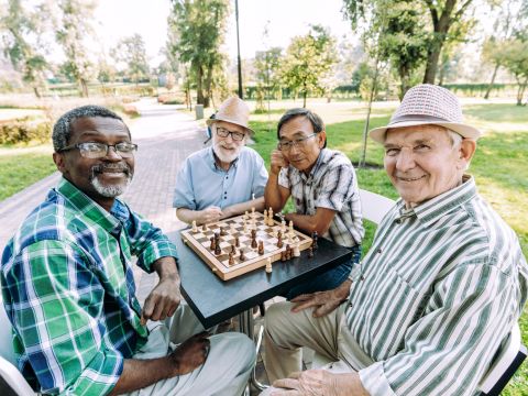 Seniors playing chess outside. 