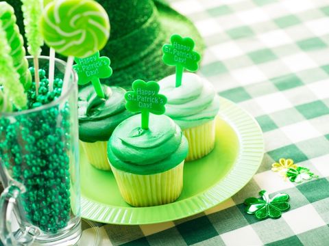 Green cupcakes and decorations on a table. 